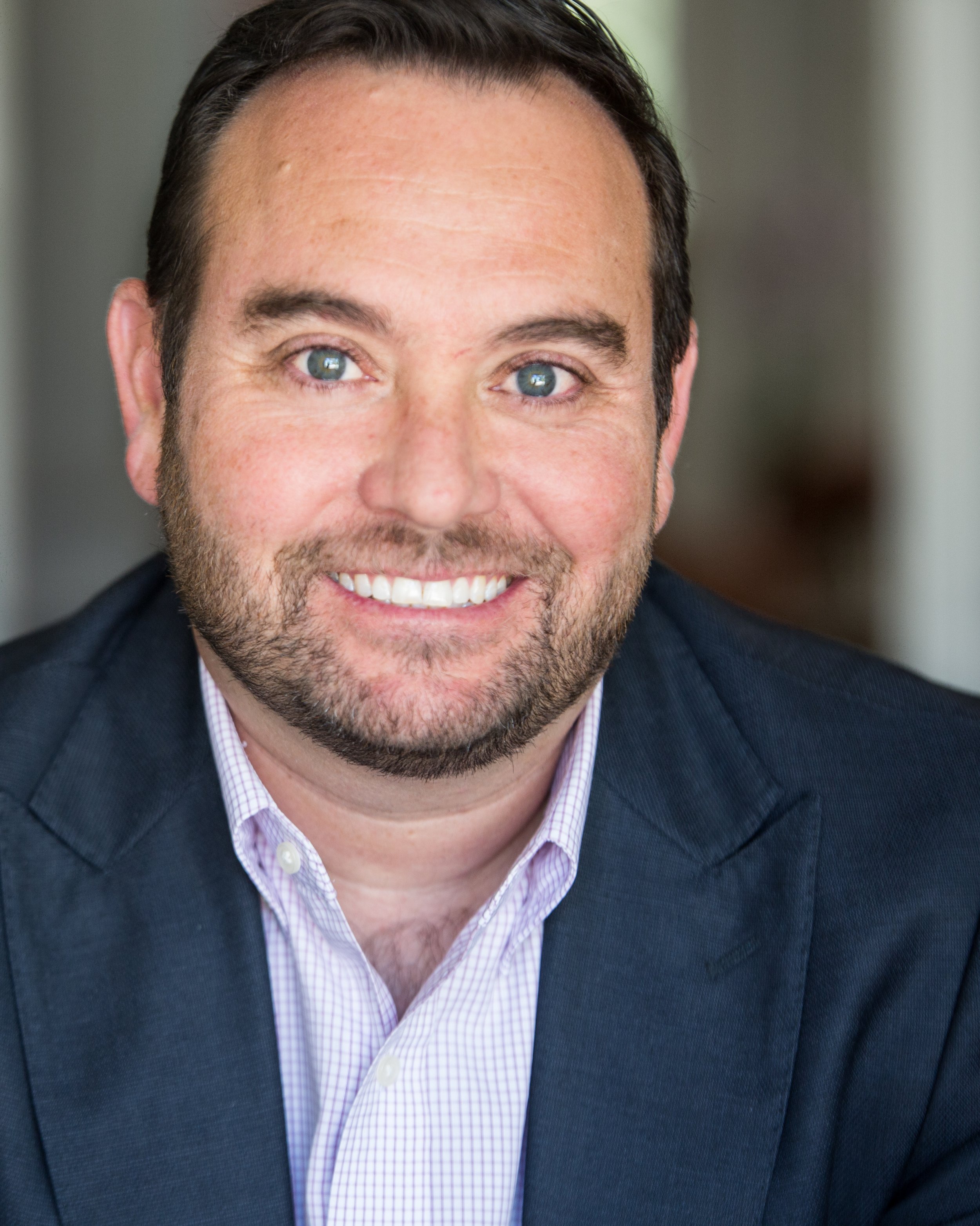 Smiling man with a beard wearing a suit and shirt